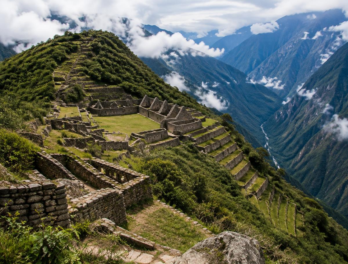 Stone terraces and buildings of Choquequirao on a ridge above the deep Apurímac canyon, with clouds